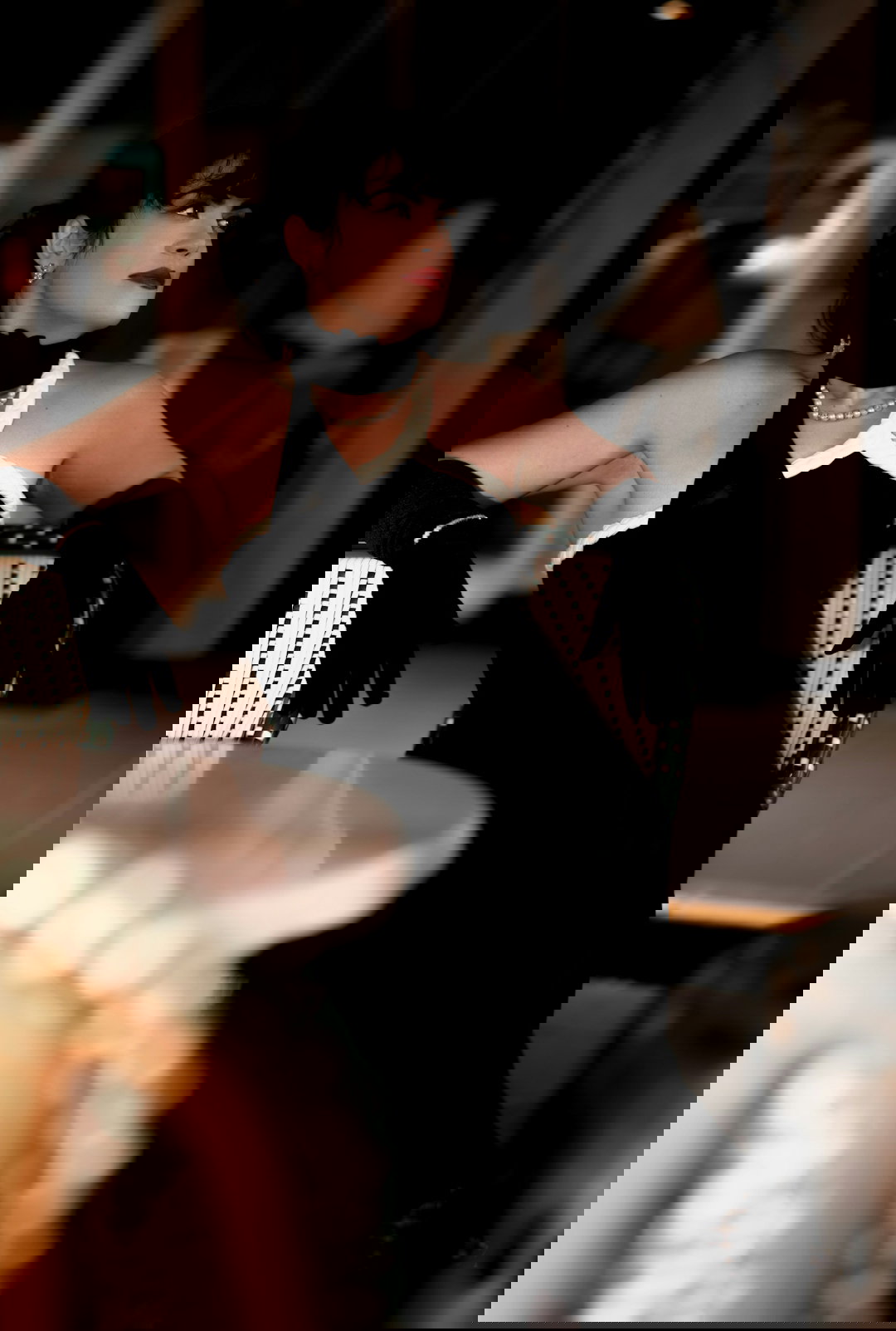 A woman in a black dress sitting on a chair